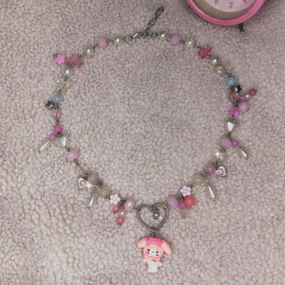 🌸Colar Onegai🌸
📦 Disponível no site, envio para todo Brasil
🎀O colar é super fofo e romântico, com um pingente da My Melody no centro, pendurado em um coração com uma linda pedra de zircônia. Todo o colar é decorado com pérolas de vidro, cristais coloridos e miçangas de diferentes formas, todos cuidadosamente interligados por um metal trabalhado à mão. Os tons de rosa predominam, dando à peça um ar delicado. É o acessório perfeito para adicionar um toque de charme e elegância ao seu visual. 