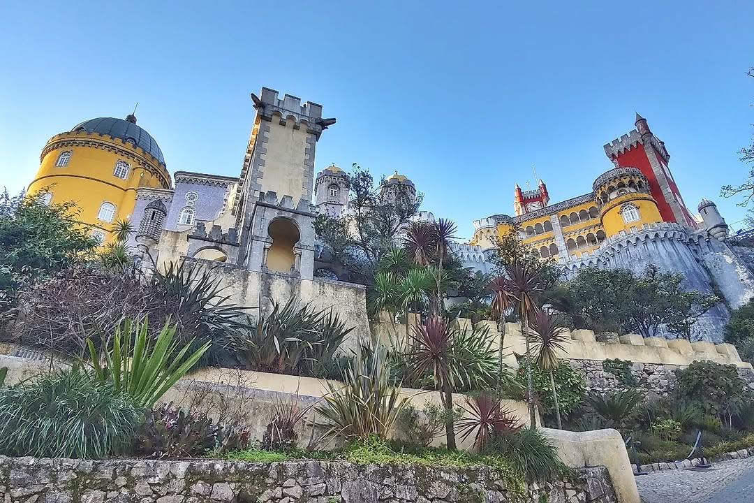 .
🌎 Saindo de Coimbra voltamos para a região de Lisboa em direção à cidade de Sintra, com pouco mais de 30 mil habitantes e a 30 Km ao oeste de Lisboa, e especificamente fomos visitar o Palácio Nacional da Pena. A paisagem da Serra de Sintra e as ruínas do antigo convento destruídas pelo grande terremoto de 1755 maravilharam o Rei Fernando II de Portugal que em 1838 decidiu comprar o velho convento, a cerca envolvente, o Castelo dos Mouros e quintas e matas circundantes, com a intenção de fazer